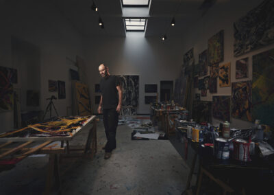 Ein Künstler steht in einem dunklen Atelier